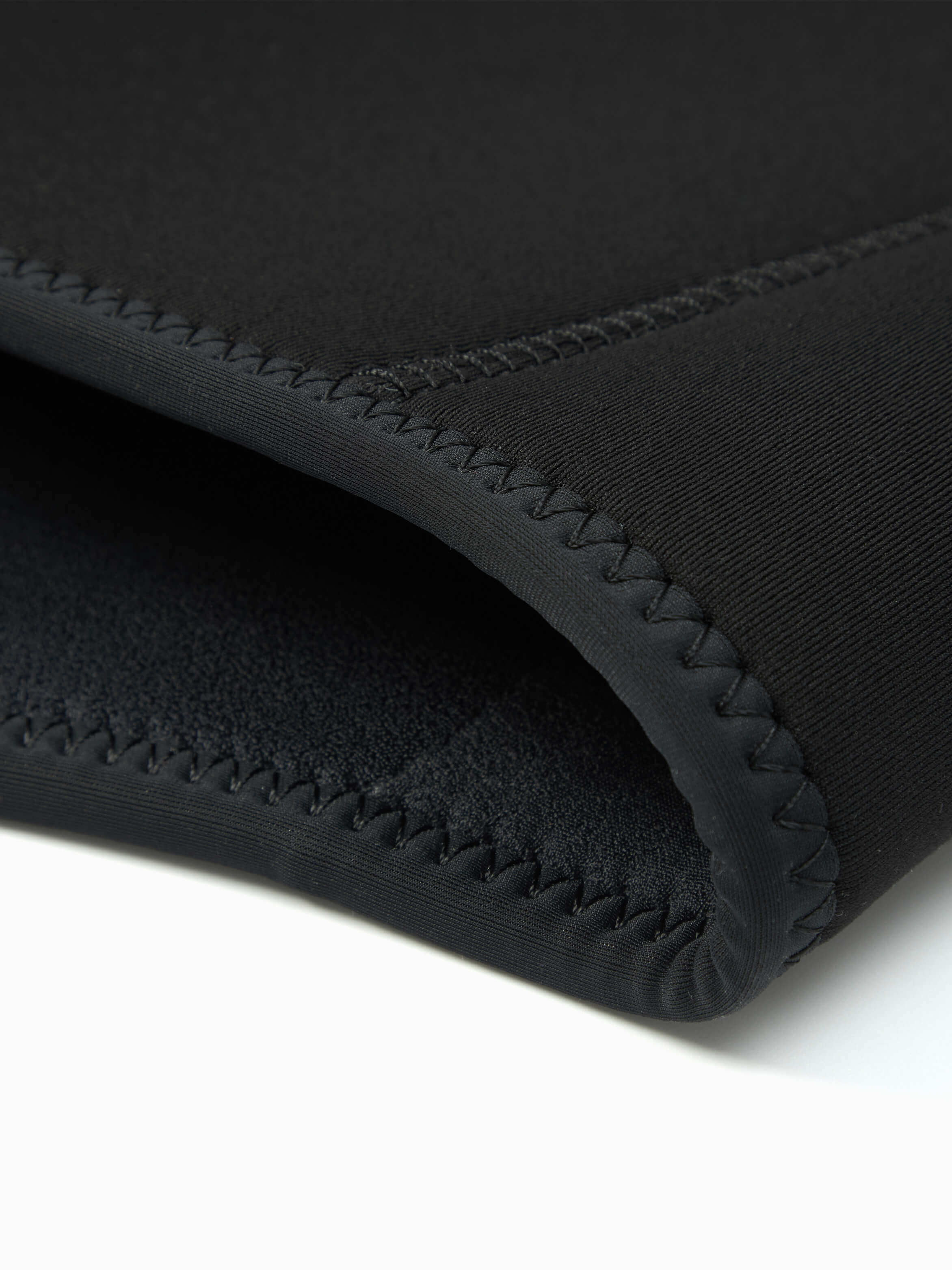 Close up of the stitched edges of the 4mm womens wet suit at the base of the jacket.