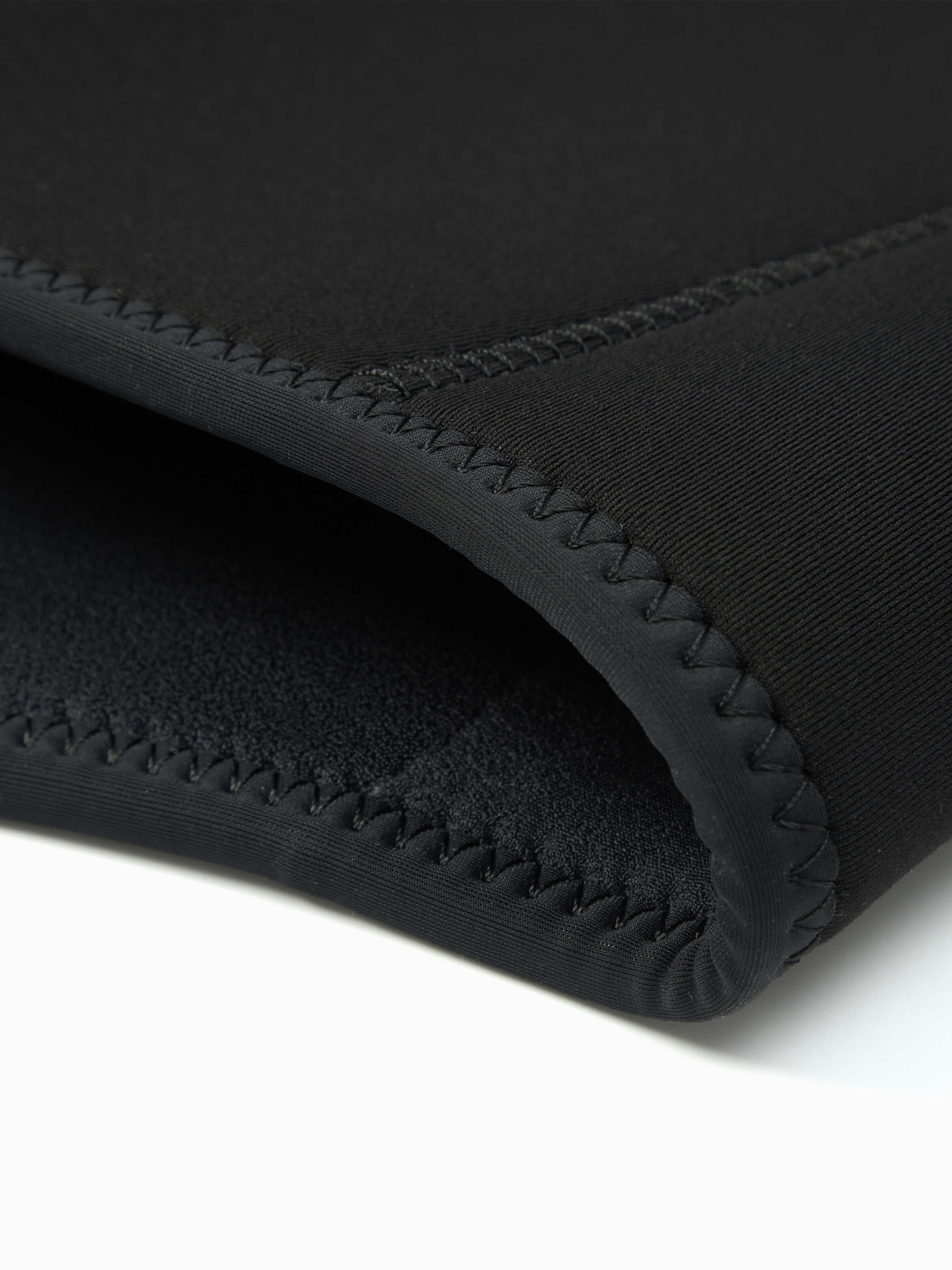 Close up of the stitched edges of the 5mm mens wet suit at the base of the jacket.