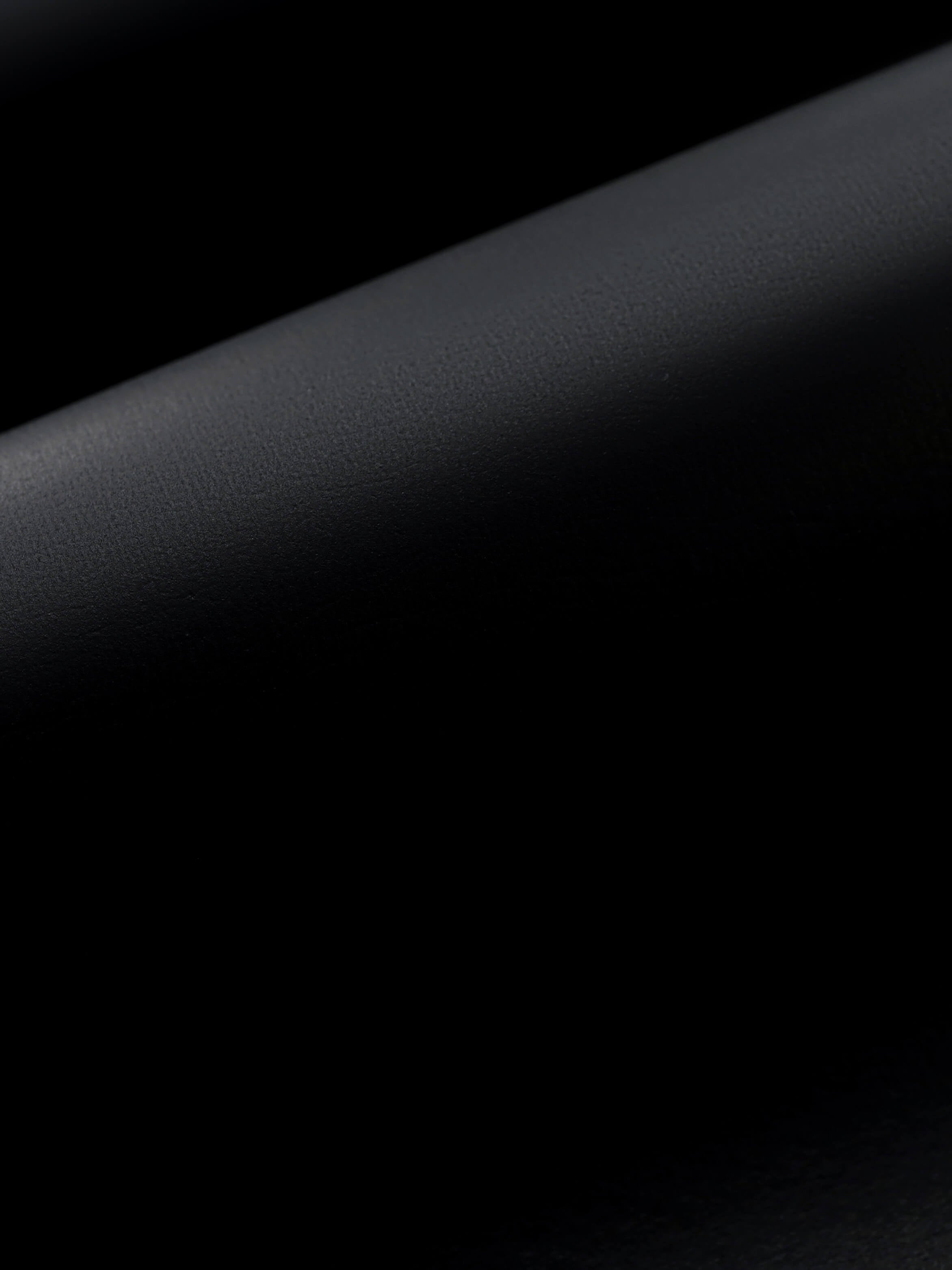 Light shining on the black smooth outer coating on professional freediving wetsuits for women